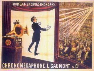 Illustration of a theater from the rear of the stage. At the front of the stage, a screen hangs. In the foreground is a gramophone with two horns. In the background, a large audience is seated at orchestra level and on several balconies. The words "Chronomégaphone" and "Gaumont" appear at both the bottom of the illustration and, in reverse, at the top of the projection screen.