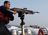 A member of a U.S. Coast Guard Maritime Safety and Security Team mans an M240B aboard a 25-foot (7.6 m) Response Boat – Small.