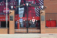 Grand portail décoré fermant l'entrée d'un stade.