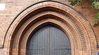 Iglesia de San Olave, arco escalonado y moldeado sobre la puerta sur con ladrillos ornamentales