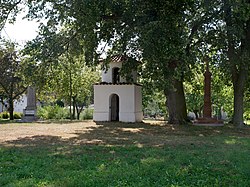 Střed návsi: zleva pomník padlým, kaple se zvoničkou, kamenný kříž