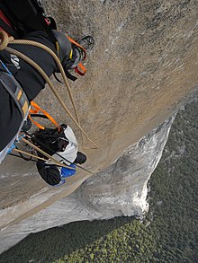 Photographie d'une personne, escaladant une montagne, montrant le sol.