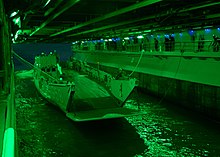 A Boatswain's Mate directs a Landing Craft Utility during wet well operations on board USS Wasp USS Wasp (LHD-1) welldeck 2.jpg