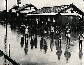 大雨で冠水した甲州街道と子供たち。現在の甲府市酒折地区の城東通り。1925年（大正14年）8月の撮影。