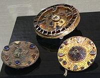 Fíbulas de disco merovíngio dos séculos VI e VII com gemas e filigranas