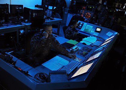 U.S. Navy officers aboard the aircraft carrier USS Abraham Lincoln monitor defense systems during early 2010s maritime security operations exercises