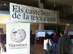 Castellers i Viquipèdia; la foto no és un gran què, però és curiosa... i que en una exposició de fotos de la Viquipèdia hi surti el logo, tampoc ho trobo malament...