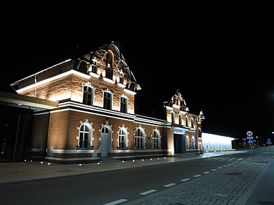 Photographie de nuit d'un bâtiment en briques rouges illuminé.