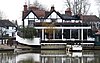 An image of a Tudor style building next to a river