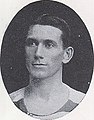 A black and white photograph of a head shot of a Caucasian man with hair slicked to the side.