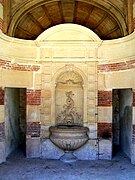 Grandes écuries, fontaine à l'entrée au centre du bâtiment.