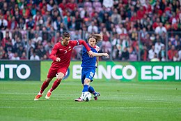 Ronaldo evading Luka Modric during a friendly match against Croatia in 2013 Cristiano Ronaldo (L), Luka Modric (R) - Croatia vs. Portugal, 10th June 2013.jpg