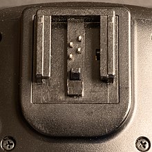 Connector has four small protruding metal pins near the centre, with a plastic side rails and a plastic mechanically retractable part to lock in place.