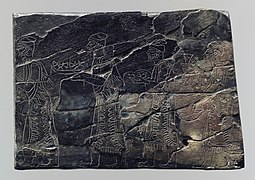 Plaque en ivoire de style assyrien (noircie par un incendie) représentant des porteurs de tribut. Nimroud, temple de Nabû, IXe – VIIIe siècle av. J.-C. Metropolitan Museum of Art.