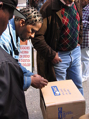 A shell game is performed on a cardboard box w...