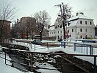 Pełcznica river and the historic Pod Lwami House ("Under the Lions") on the right, in wintertime