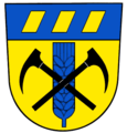 Gemeinde Welschbach Unter blauem Schildhaupt, darin balkenweise drei goldene Schindeln, in Gold eine blaue Ähre, belegt von zwei schwarzen gekreuzten Bergmannspickeln.[29]