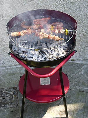 Italiano: Barbecue con spiedini e salciccia al...