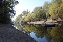 Wassergraben mit Bäumen und Boot