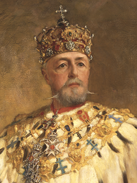 Пожилой бородатый мужчина в богато украшенной мантии, в украшенной драгоценными камнями короне, увенчанной крестом, выглядит прямо из картины.