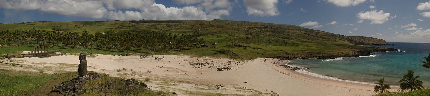 Panorama de la sablera Anakena. El moái de la fotografía foi'l primeru en ser reerigido sobre'l so ahu en 1955 por habitantes de la islla utilizando'l métodu orixinal.