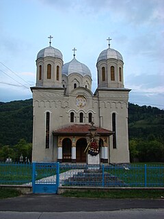 A falu 1939-ben épült ortodox temploma, előtte a Crişan által erőszakkal ortodox hitre térített és egy Toader Clej nevű paraszttal összeadott Csiszár Katalinra, illetve a felkelés leverése után kerékbe tört parasztokra emlékeztető kereszt