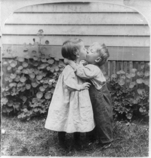 Two small children kissing.
