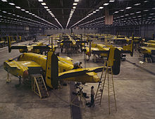 Photographie d'un vaste hangar dans lequel se trouvent plusieurs dizaines d'avions de couleur jaune.