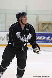 hockey player in a black and white uniform with a crown logo on his ...