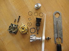 A Cox Babe Bee 0.049 in (0.80 cm) reed valve engine, disassembled, uses glow-plug ignition. Its mass is 64 g. Old Cox Babe Bee engine dissasembled.JPG