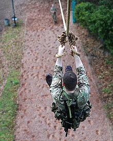 A recruit, at the start of the 'Tarzan Assault Course slides down the death slide (known as the Commando Slide).
