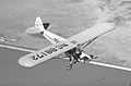 Pilot se snaží za letu nastartovat motor letounu Piper J-3 Cub