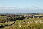 Foto von einer Anhöhe auf eine Siedlung im weitgehend flachem Gebiet herunter