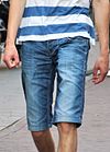Mladý muž na sobě jorty (džínové kraťasy) (oříznuté) .jpg