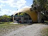 One of the two "Bubble Houses" in Hobe Sound, Florida, behind a palm tree.