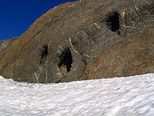 Photographie montrant trois cavités creusées dans la roche.