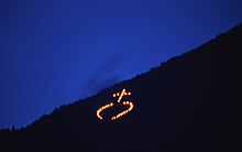 A traditional Herz-Jesu-Feuer ("Sacred Heart fire") on the slope of Mount Ifinger in South Tyrol, Italy, 2009. Herz Jesu Fires - South Tyrol.jpg
