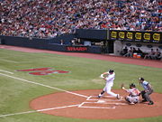 Joe Mauer swinging against Baltimore, catcher and umpire visible, in front of Metrodome crowd
