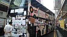 A double-decker bus in Mong Kok is used as a message board Messages supporting 2014 Hong Kong protests cover bus-WA0008.jpg