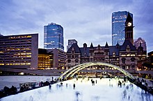 Nathan Phillips Square is a public square and landmark in downtown Toronto. Old City Hall, another landmark in the area, is visible in the background. Skaters at dusk.jpg