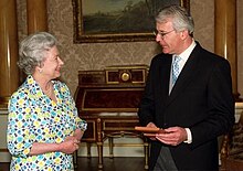 Major receiving the insignia of a Member of the Order of the Companions of Honour from the Queen at Buckingham Palace, 1999 The Queen and John Major 09 Jun 1999 (7139078257).jpg