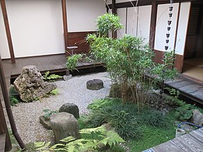 A square garden courtyard, about 2m on each side, with an engawa of broad dark boards about 30 centimetres (12 in) above the pale gravel.