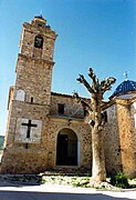 Vista frontal de la fachada de la iglesia parroquial de Puebla de San Miguel (Valencia), con detalle del viejo olmo seco, año 2004.