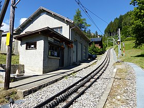 Vue générale de la gare de Crêt-d'y-Bau avec la voie, le quai et le bâtiment de la gare.