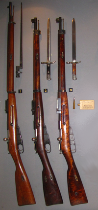 Från vänster, med tillhörande bajonett: 1) Infanterigevär M/91-24 (”Lotta-geväret”), 2) Skyddskårgevär M/28 "Spetsöra", 3) Skyddskårgevär M/28-30 "Spetsöra", Krigsmaktens "järndos": 5-pack 7,62×53R bredvid en patron för jämförelse.