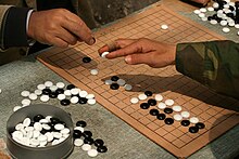 Go players demonstrating the traditional technique of holding a stone Playing weiqi in Shanghai.jpg