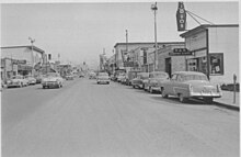 Fourth Avenue in 1953, looking east from near I Street. Just ten years before, the retail area shown in the foreground was mostly an industrial area, housing lumber yards and similar uses. Anchorage 1953 FWS.jpg