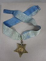 Star-shaped medal on a blue neck ribbon