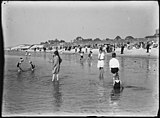 Gezicht op het strand van Bergen aan Zee vanaf het water, met op de voorgrond spelende kinderen en op de achtergrond de huizen aan de boulevard en de Pier Panderstraat