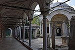 The western outer portico of the complex, part of the mektep, with the cemetery on the right